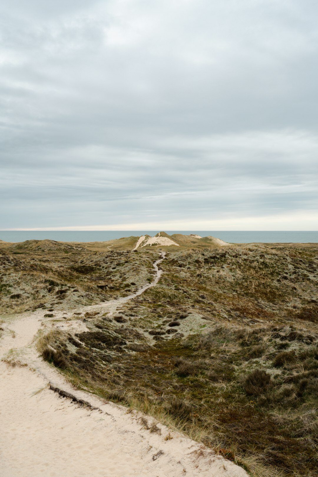 Elderly Danish couple walking together along a coastal path in Denmark